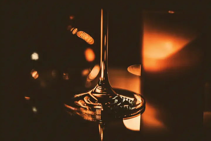 The stem of a glass catching warm light